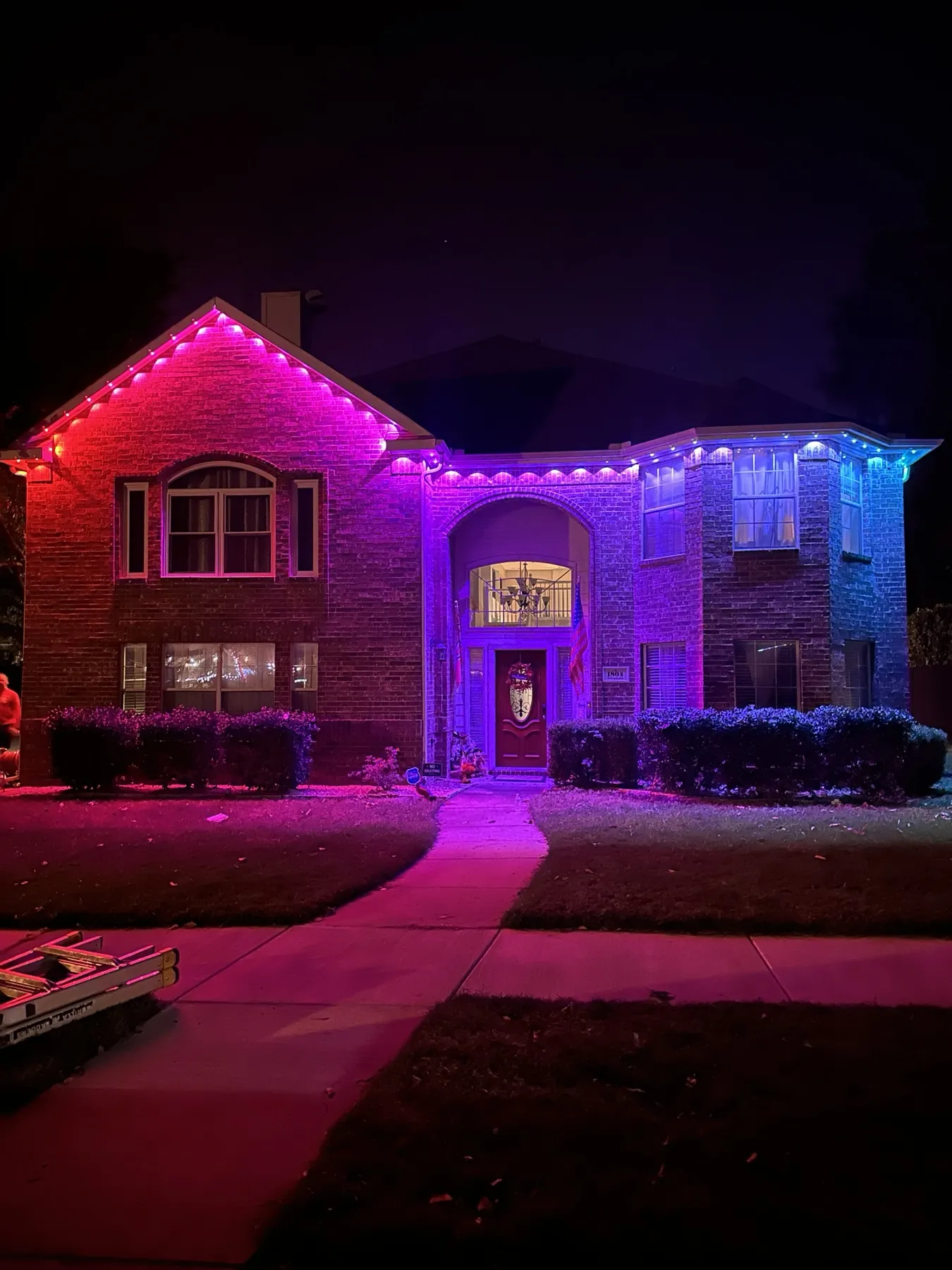 Permanent lighting in magenta and blue on a two-story brick home in DFW