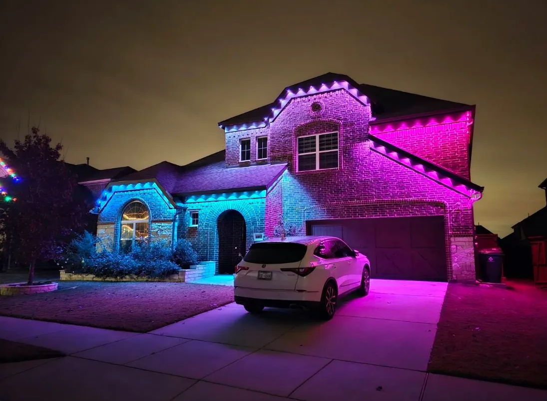 Permanent lighting in teal and magenta on a brick home in DFW that the owner controls from an app