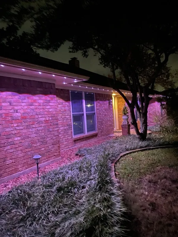 Permanent eave lighting on a single-story brick home in DFW