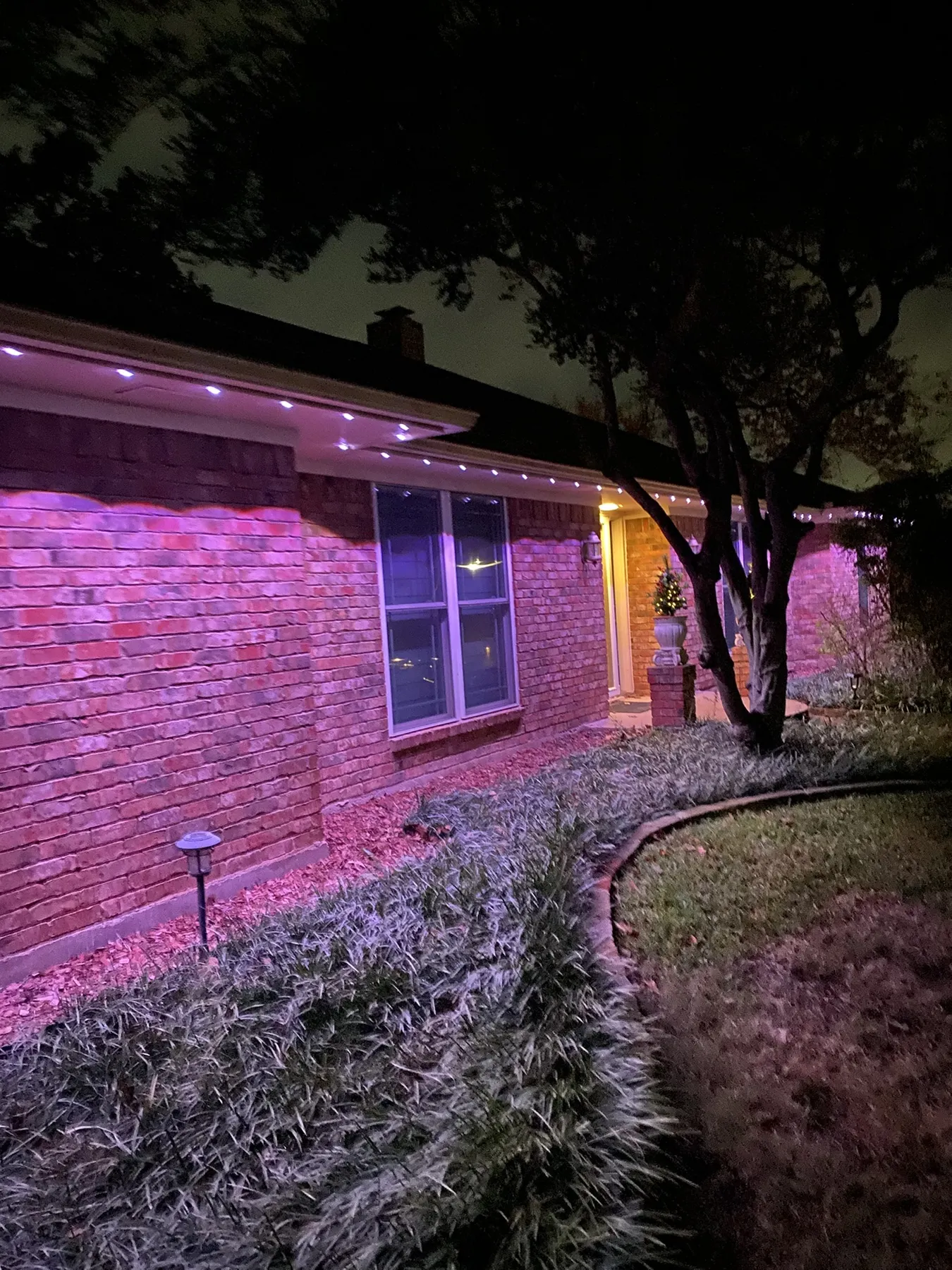 Permanent eave lighting along a single-story brick roofline in DFW